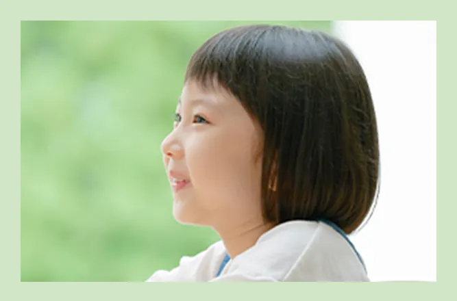 窓辺で外を眺める子どもの写真